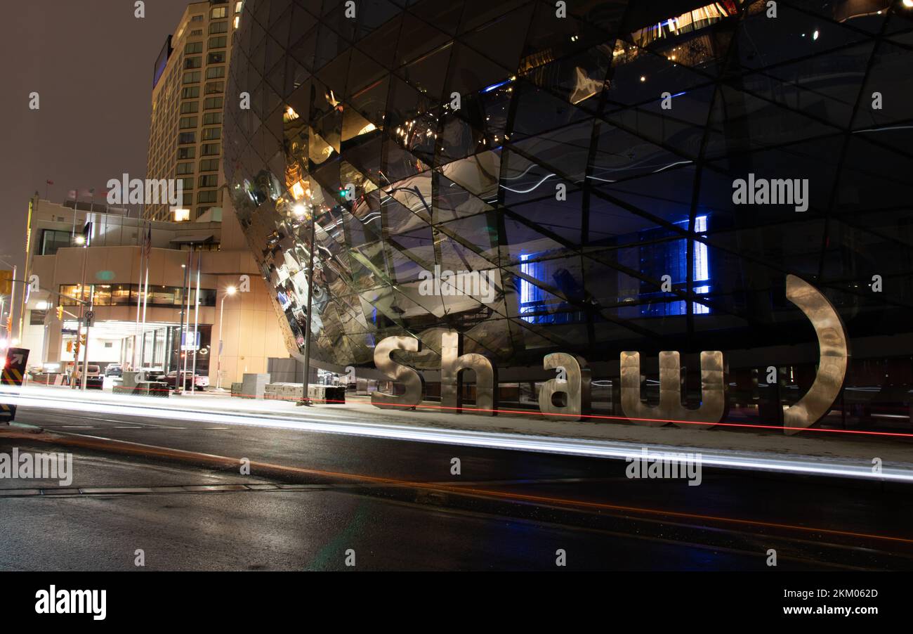 At the base of the Shaw Centre, a popular event venue in Ottawa, the Shaw Communications logo, a Canadian telecom company is seen at night. Stock Photo