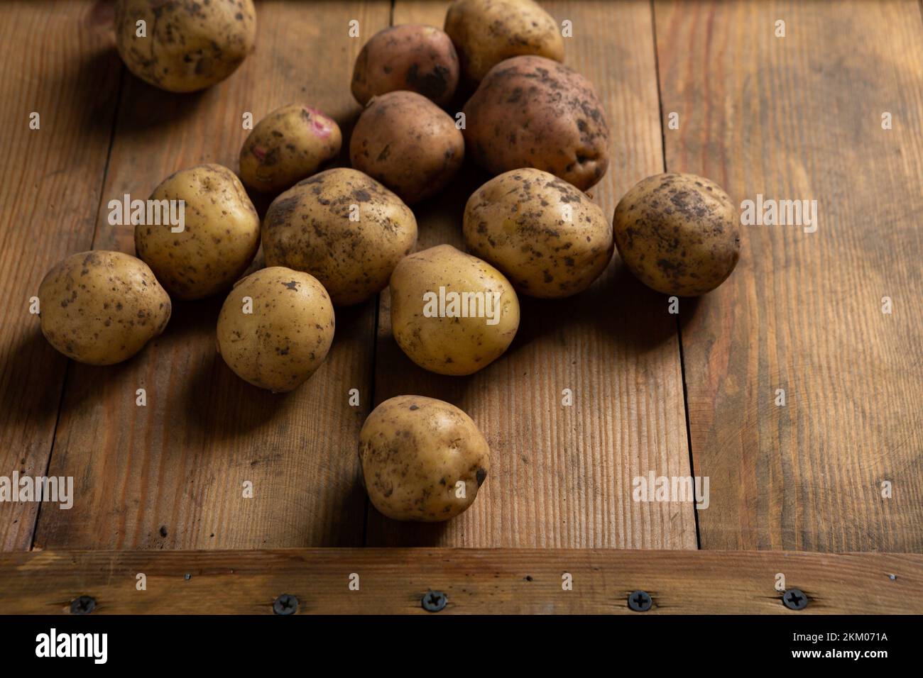 Close up of raw potatoes root on wooden board food Stock Photo