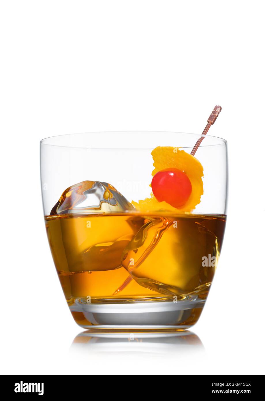 Glass with ice cubes and old fashioned cocktail with cherry and orange peel on white Stock Photo