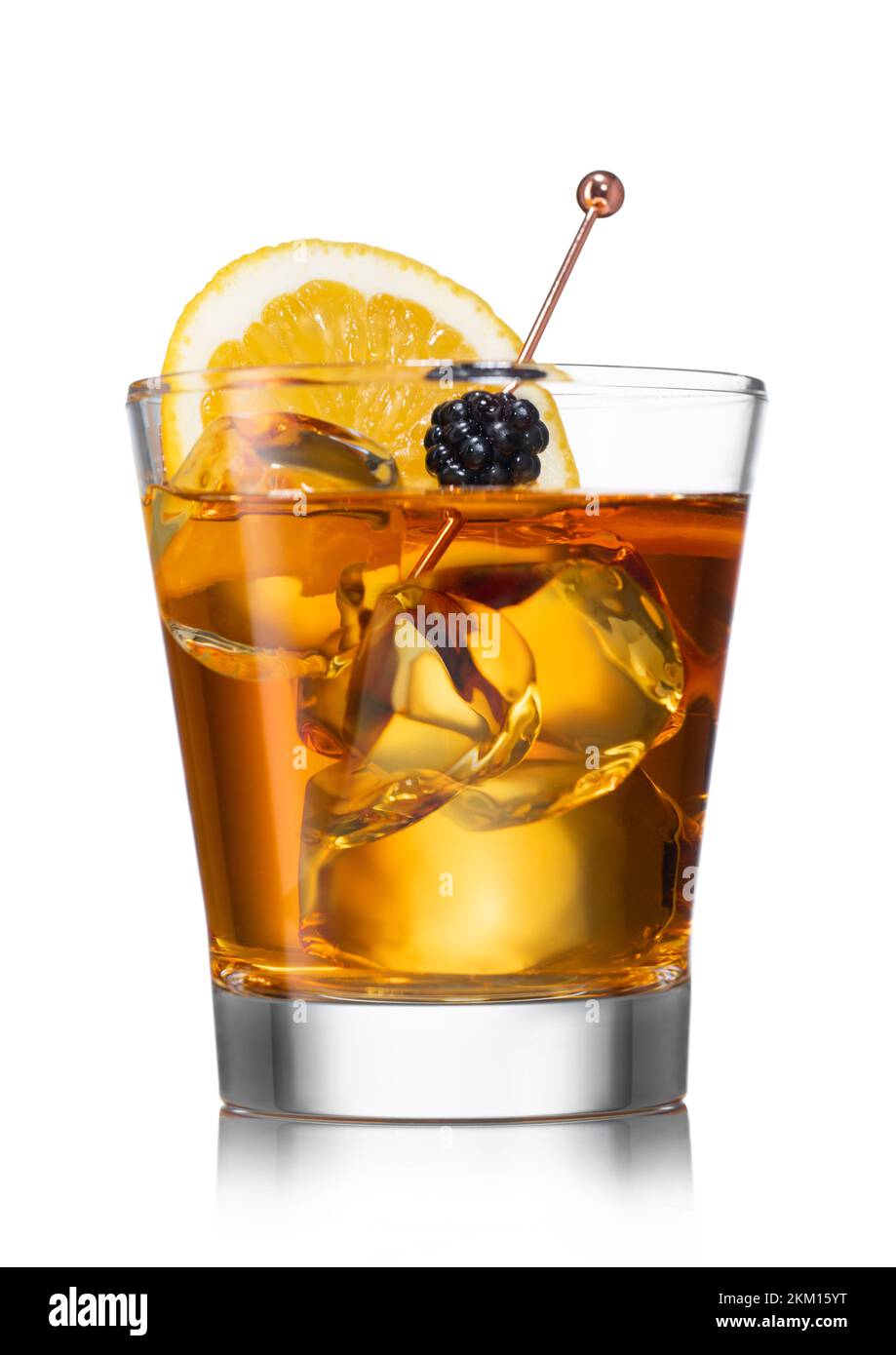 Glass of old fashioned cocktail with ice cubes and blackberry with orange on white. Whiskey,sugar,syrup and orange. Stock Photo