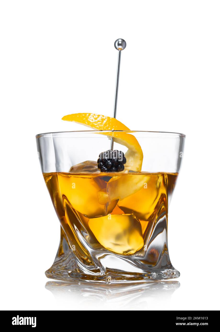 Old fashioned cocktail glass with ice cubes and blackberry on still