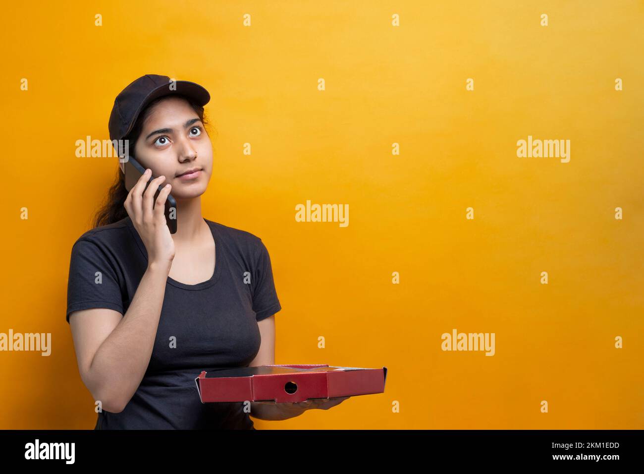 Cheerful pizza delivery Woman talking on Smart Phone Stock Photo
