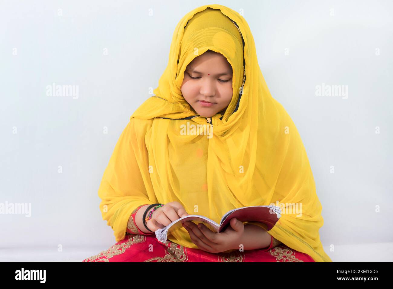 Asian Islam or Muslim child girl wearing a hijab is reading the book Stock Photo