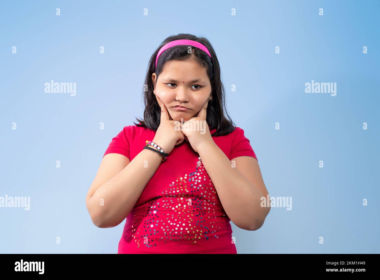 Girl cheeks pressing her fingers on her cheeks Stock Photo