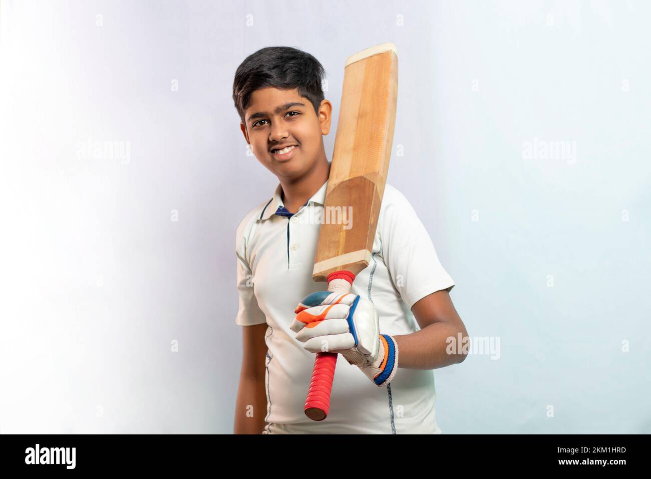 A boy in cricket uniform holding Cricket Bat Stock Photo