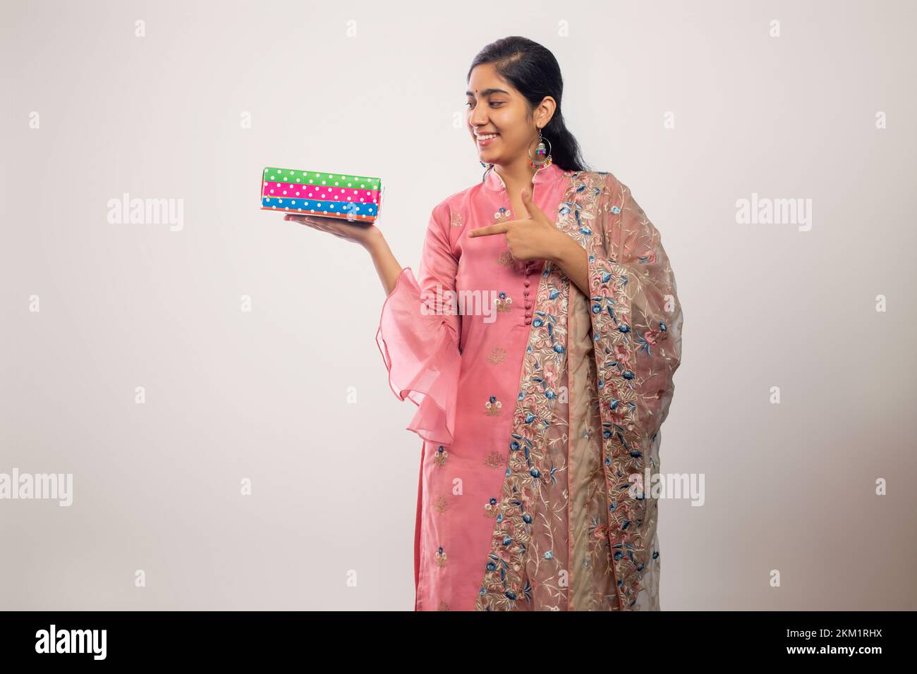 young Teenager girl  pointing a gift box on Diwali Stock Photo