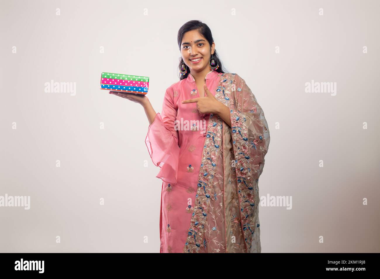 young Teenager girl  pointing a gift box on Diwali Stock Photo