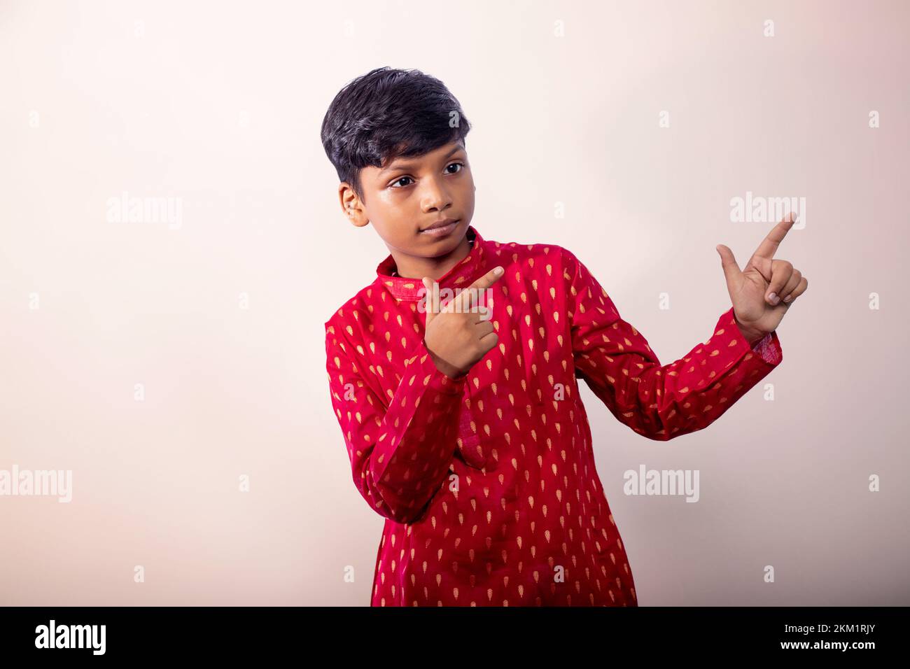 Boy wearing a traditional dress and  pointing away Stock Photo