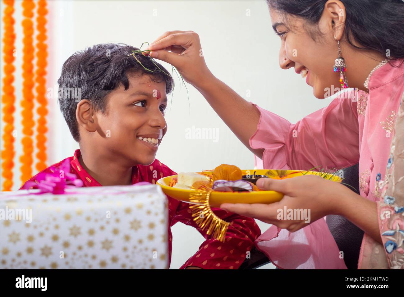 Sister doing pooja on her brother's on the occasion of Raksha Bandhan Stock Photo
