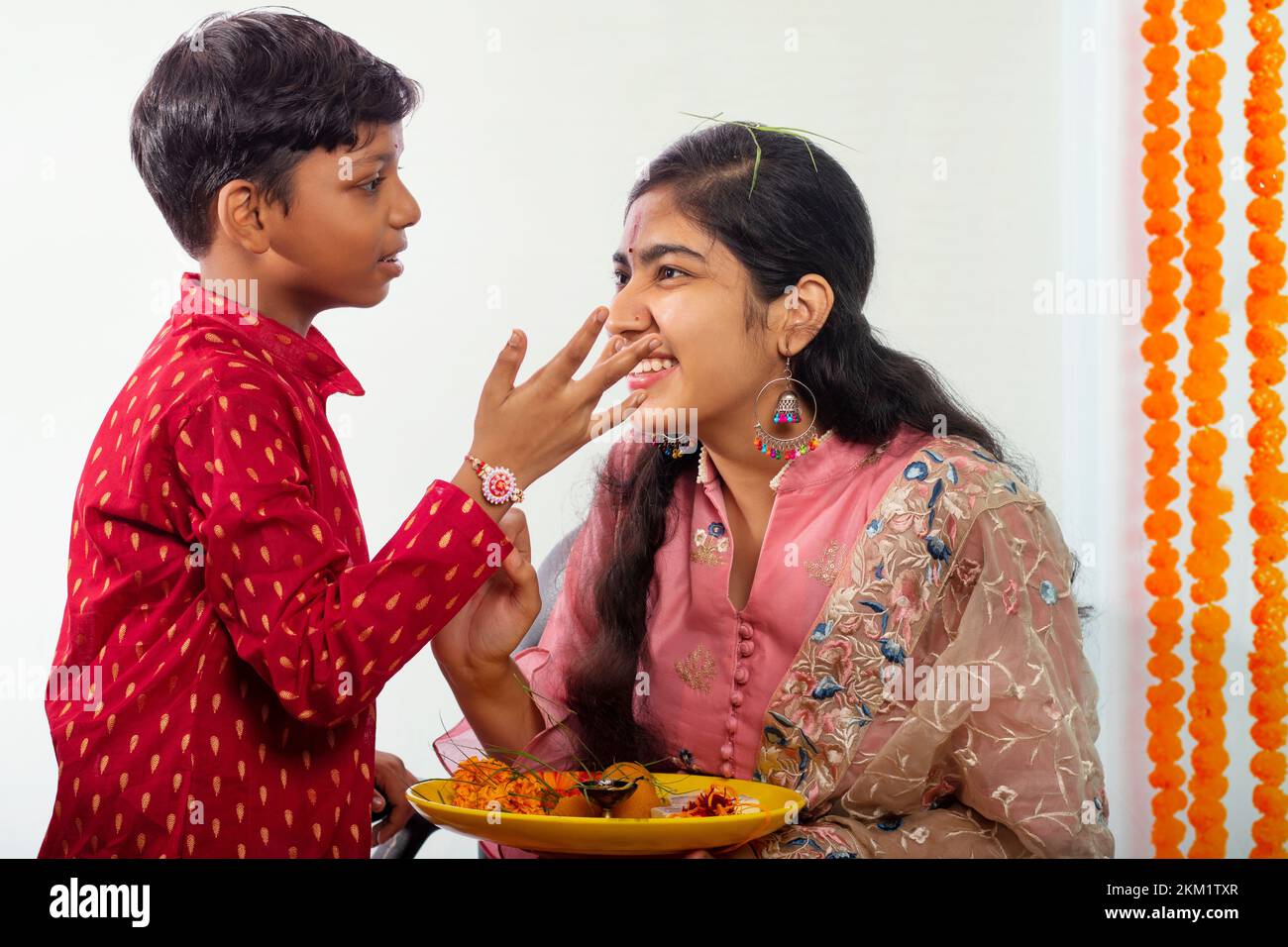 Brother applying tika on his sister's forehead on the occasion of Raksha Bandhan Stock Photo