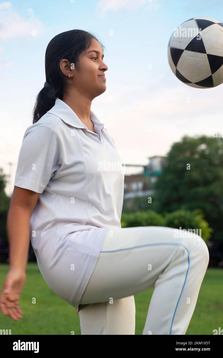 Female playing soccer ball on the field Stock Photo