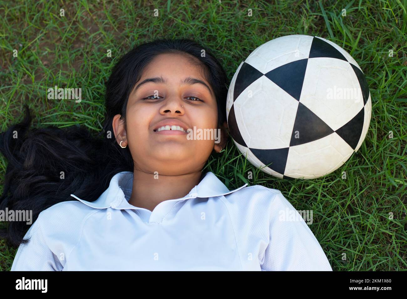 female soccer relaxing lying on the grass tired from practice Stock