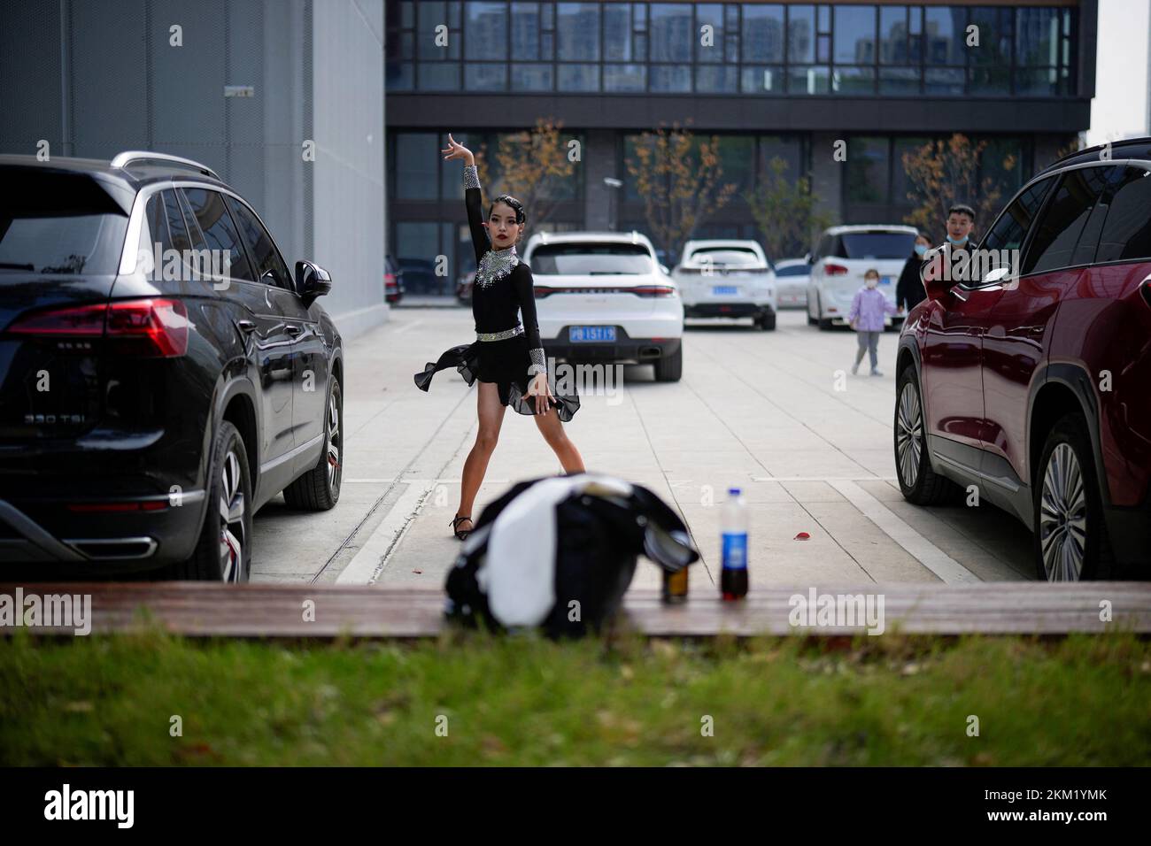 A girl practices dancing in a parking lot area, following the coronavirus disease (COVID-19) outbreak in Shanghai, China, November 26, 2022. REUTERS/Aly Song Stock Photo