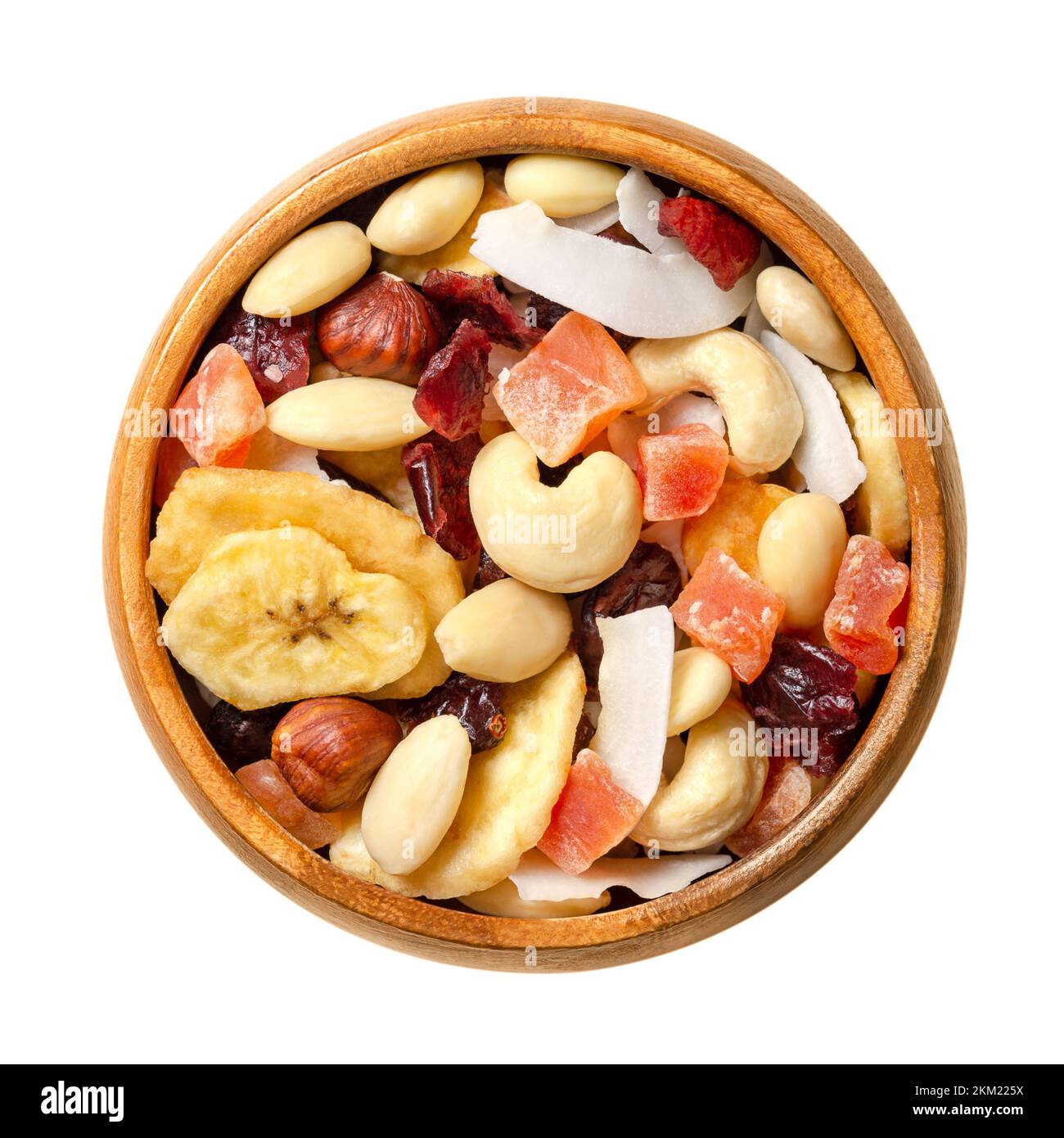 Exotic dried fruit mix with nuts, trail mix in a bowl. Dried cranberries, banana and coconut chips, candied papaya, almonds, hazelnuts and cashews. Stock Photo