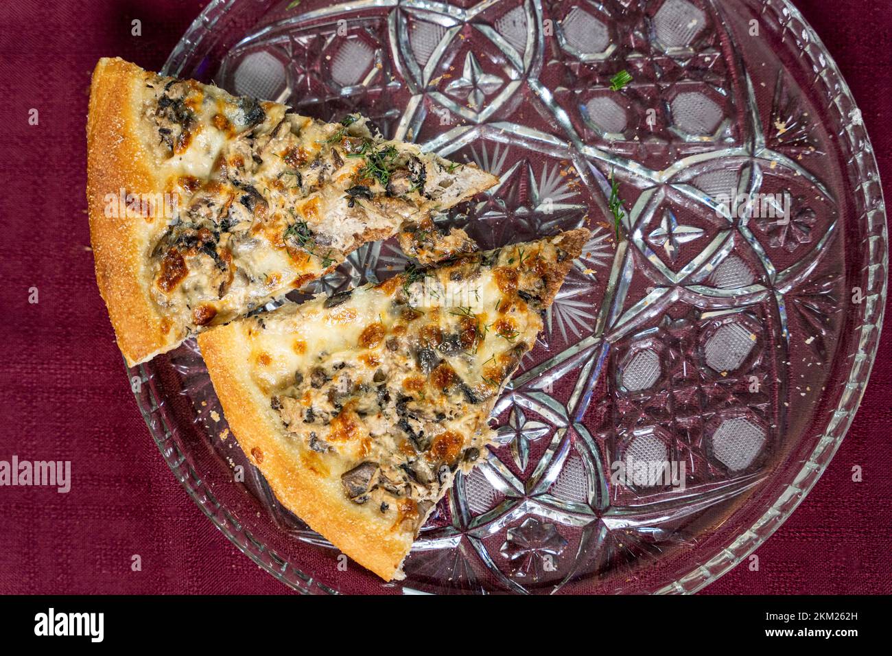 Pizza slices on a glass round tray on the table, top view Stock Photo ...