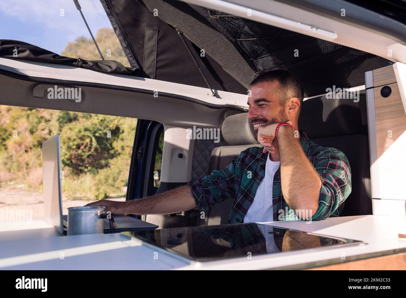 man working on his laptop from his camper van Stock Photo