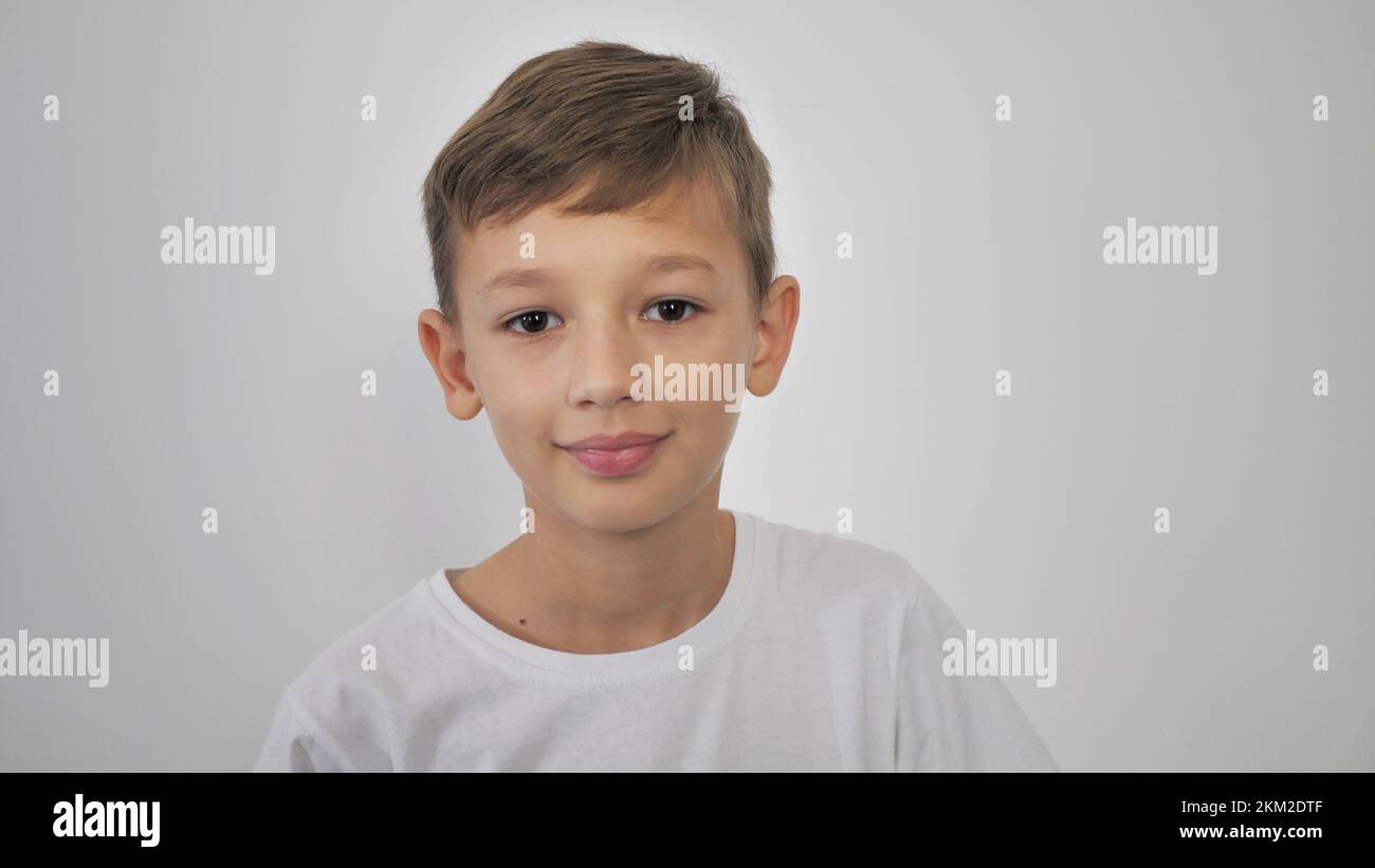 Photo of an adorable young happy boy looking at the camera. on a white ...
