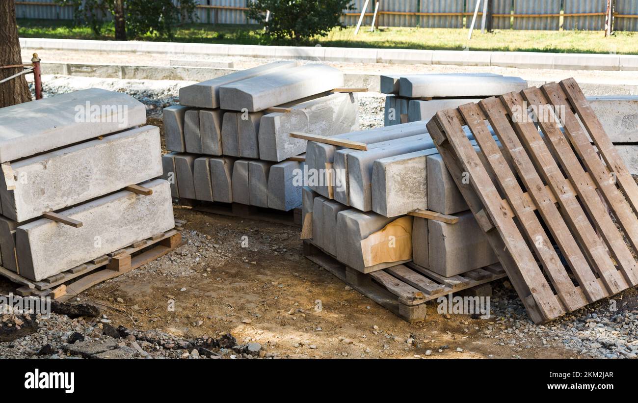 Concrete blocks and a wooden pallet on a fenced construction site in the city center. Stock Photo