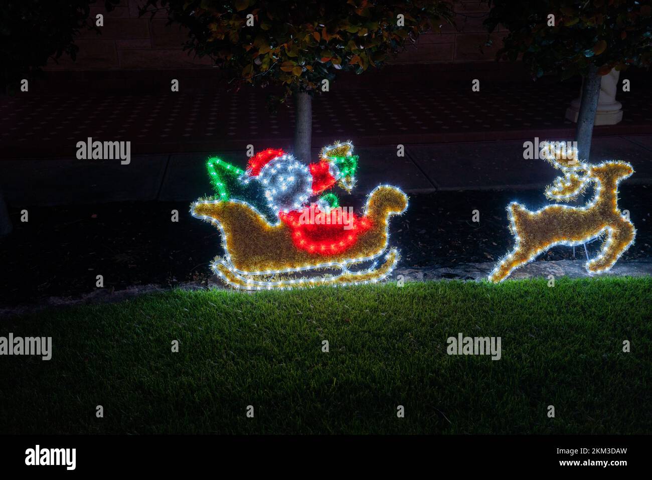 A Santa Claus on a sleigh and reindeer are illuminated  on the front garden of a residential house in Adelaide, South Australia Stock Photo