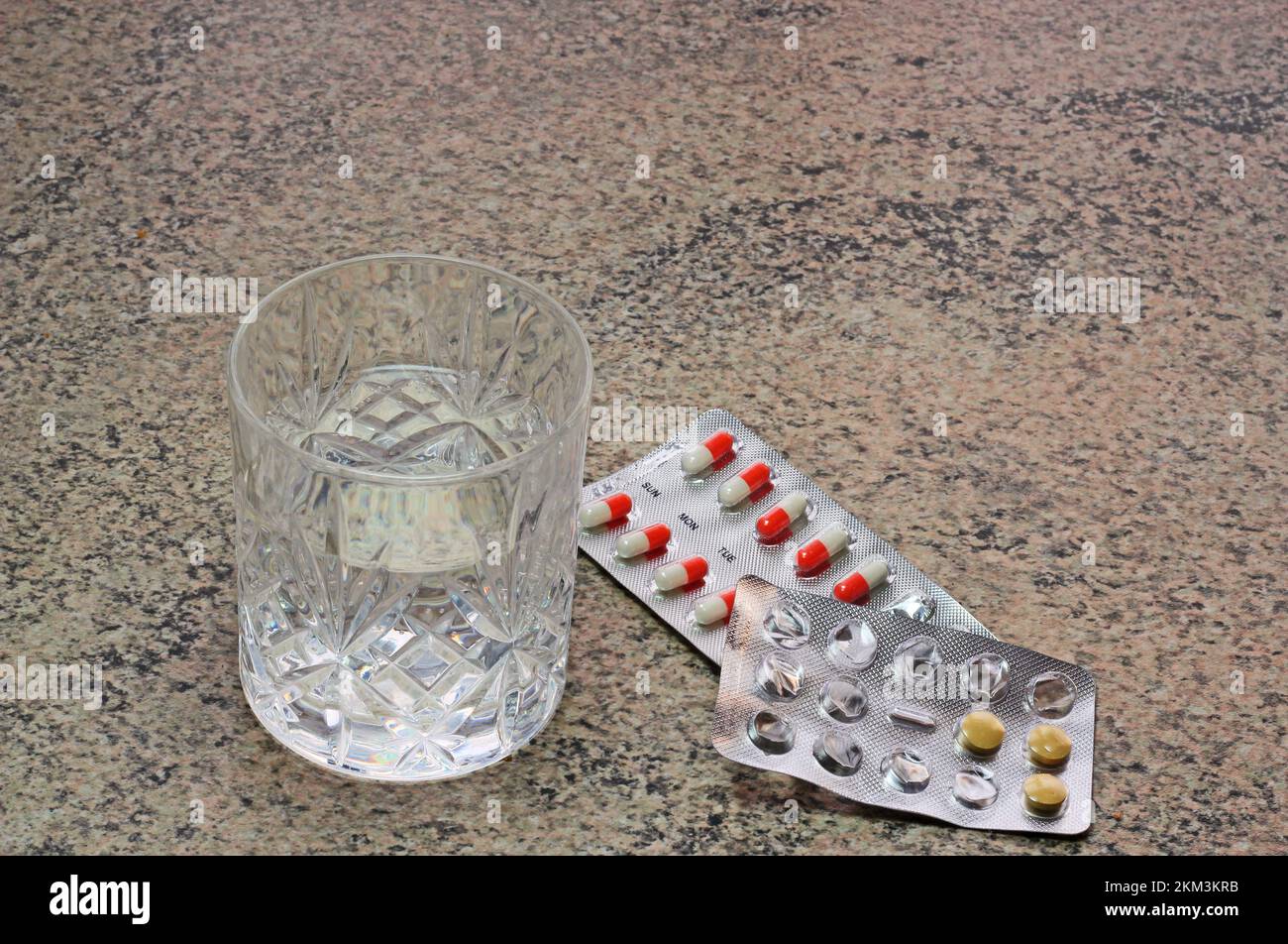 Glass of water and tablets or pills to take. medicine. Stock Photo