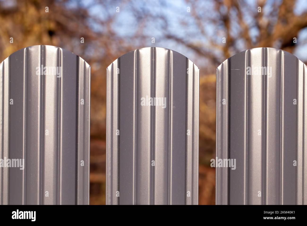 the upper part of a metal fence painted with gray paint, part of a metal fence on a private