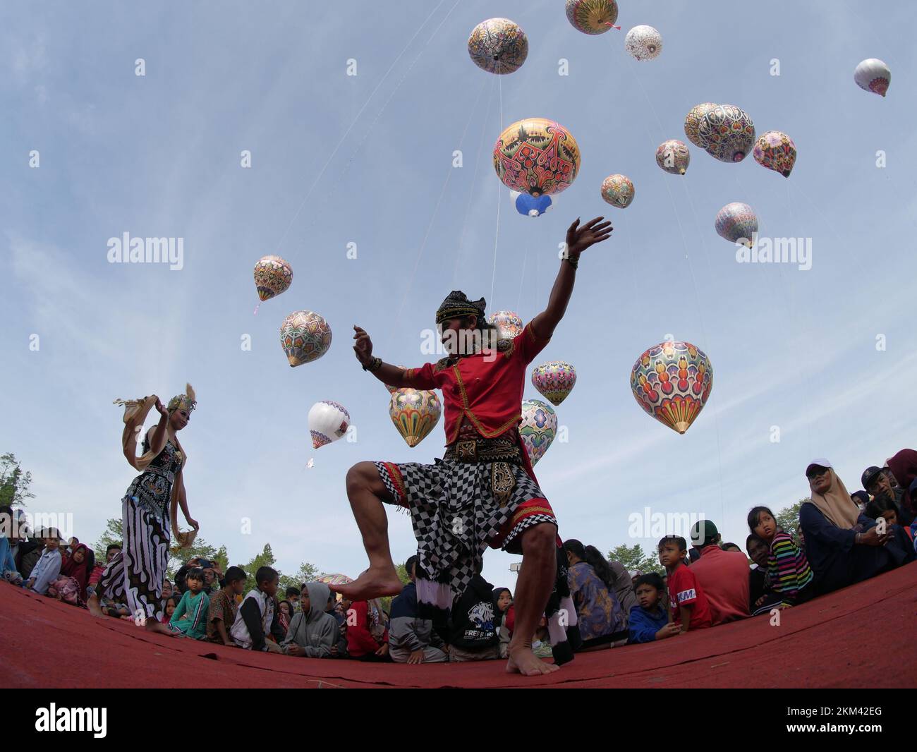 Lengger dancers from Wonosobo Regency, Central Java, Indonesia dance against a backdrop of hot air balloons Stock Photo