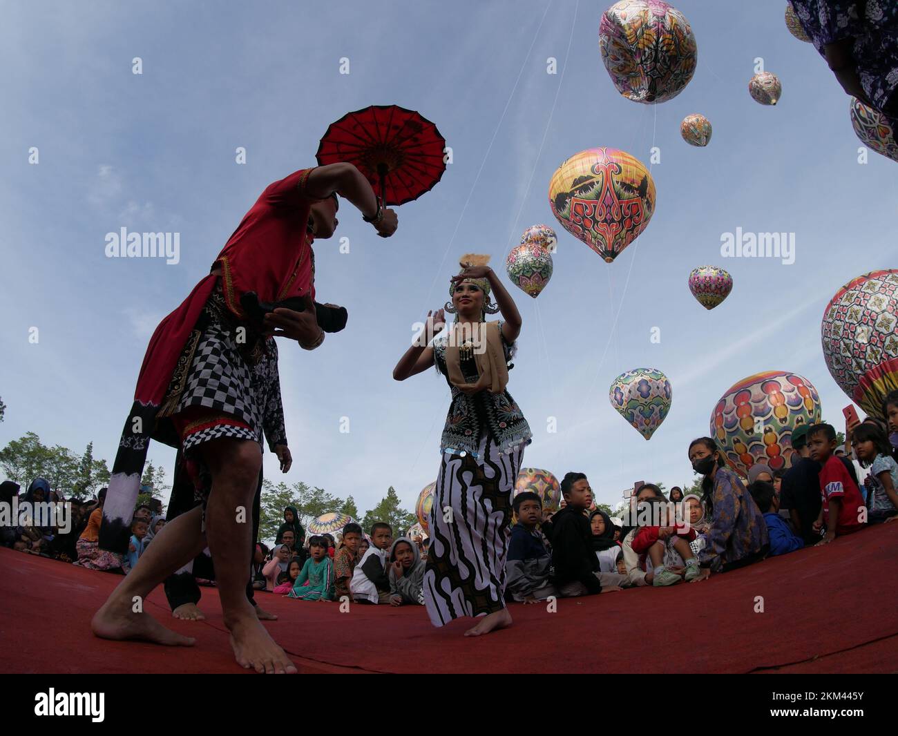 Lengger dancers from Wonosobo Regency, Central Java, Indonesia dance against a backdrop of hot air balloons Stock Photo