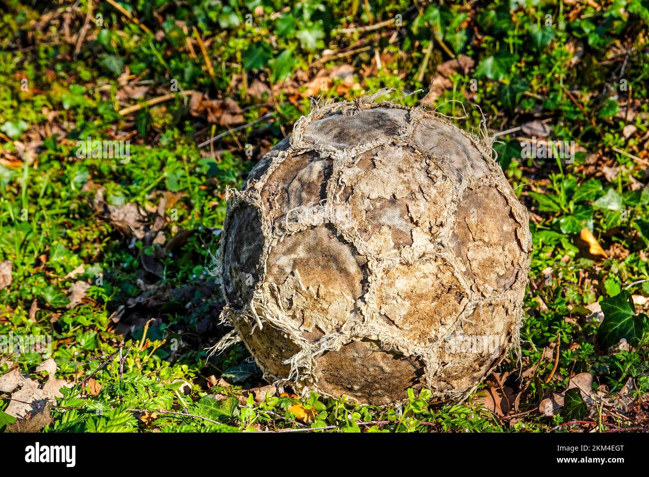 Old, totally worn out soccer ball or football Stock Photo