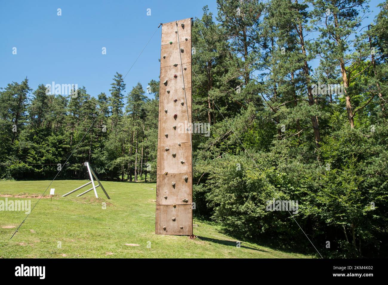 Artificial rock climbing wall outdoor on mountain meadow Stock Photo