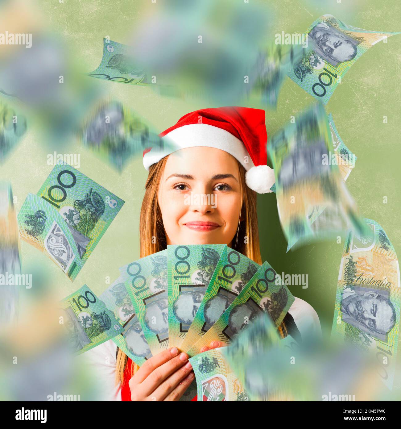 Creative green cash photo on a christmas woman celebrating a win with Australian 100 Dollar money fan. Savings in Australia Stock Photo