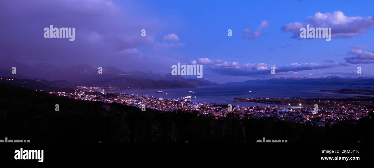 The City of Ushuaia, Argentina, at night, where the harbor meets the city and the mountains in the background. Stock Photo