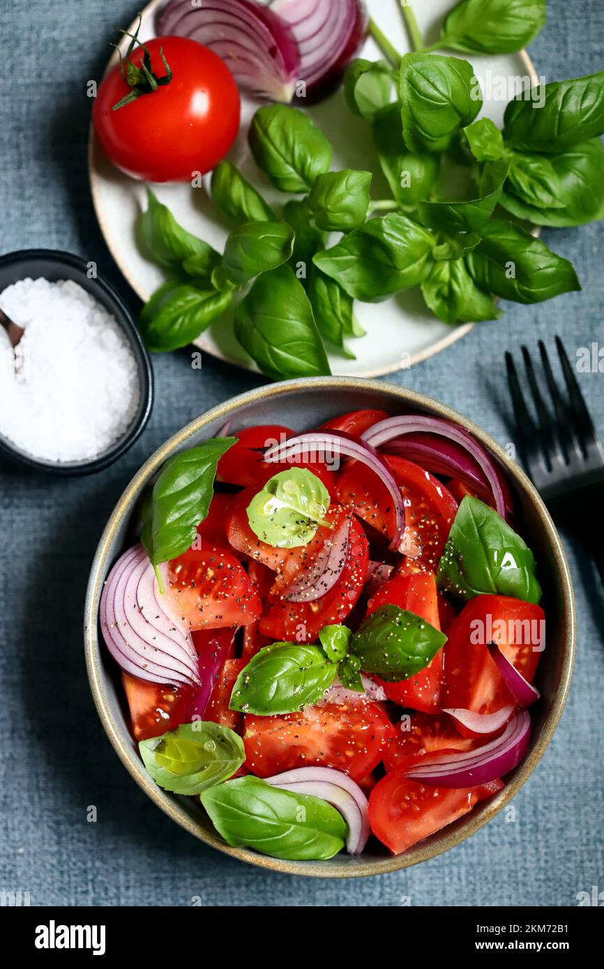 Juicy salad with tomatoes, basil and blue onion. Stock Photo
