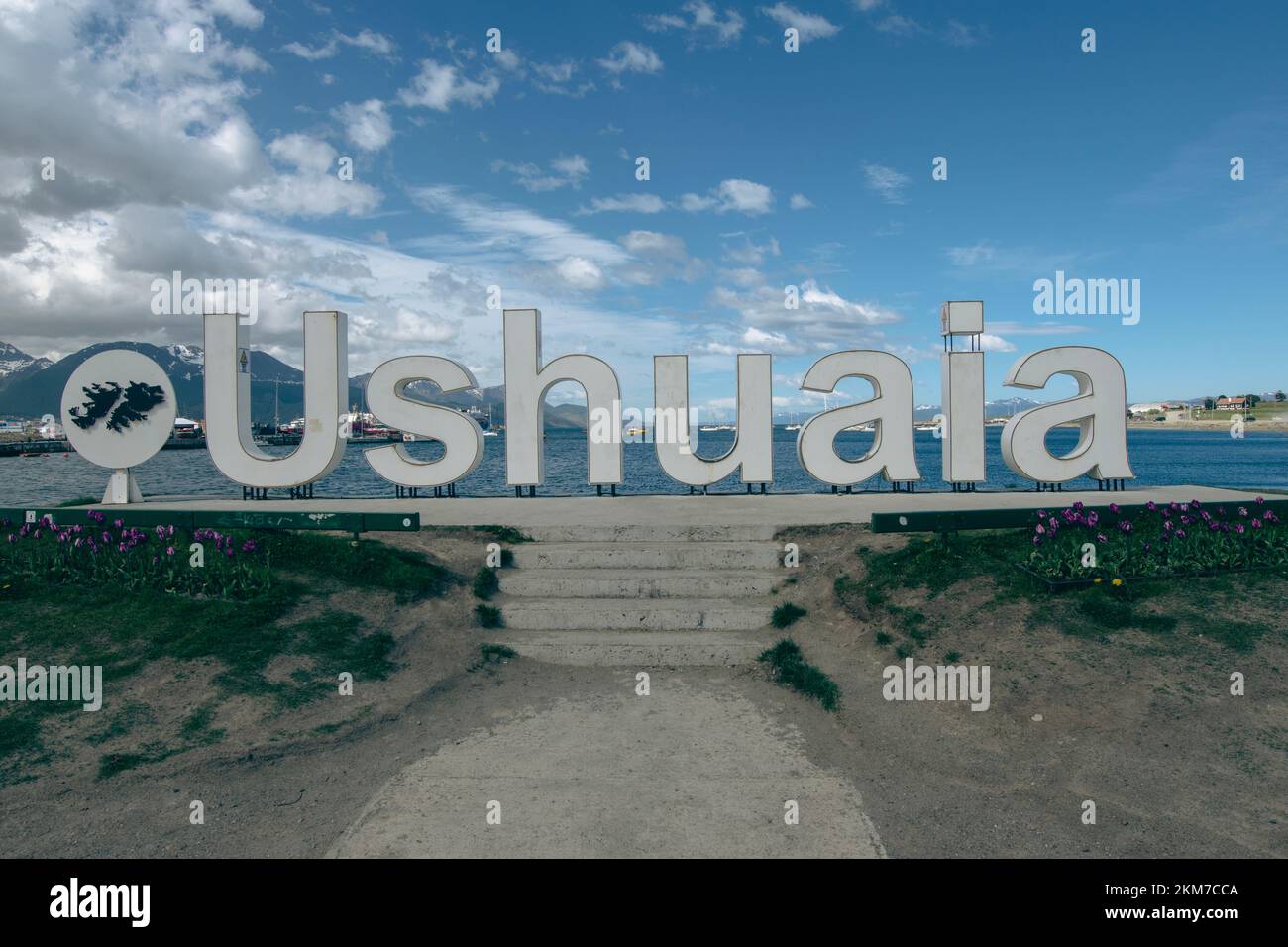 Looking out at the ocean behind the Ushuaia Sign in Argentina. Stock Photo