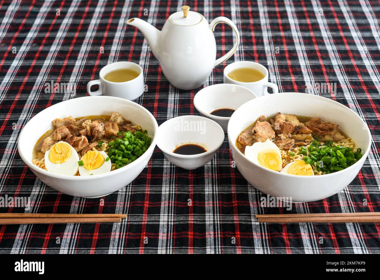 Japanese ramen with chicken and soy sauce on the table with teapot and