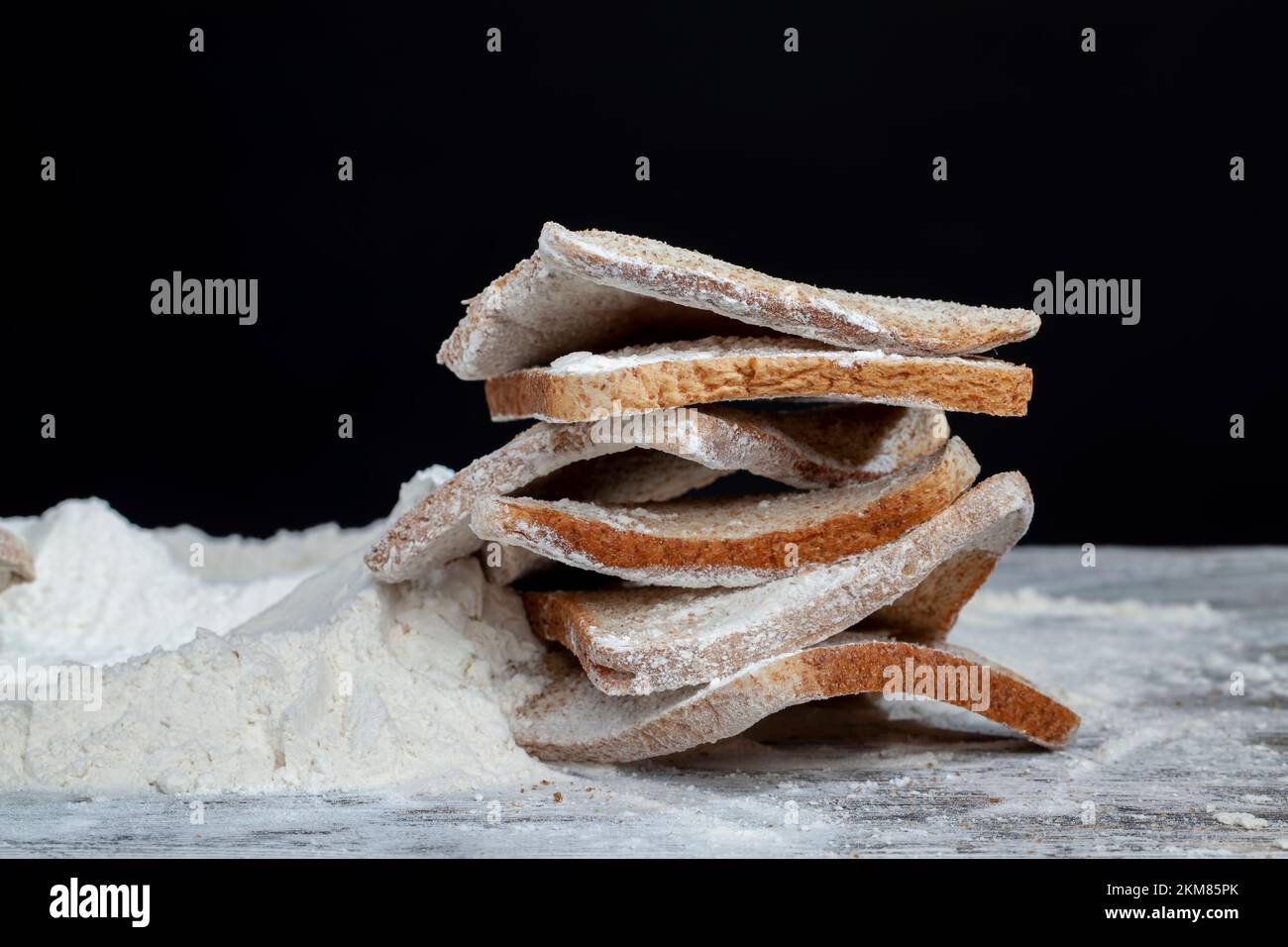 wheat flour bread and wheat flour on a board, thin broken wheat bread