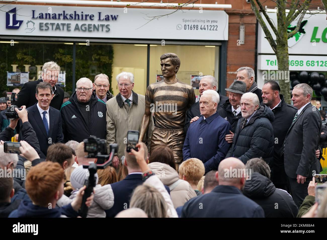 Former Celtic players Frank McAvennie (left), John Fallon (third left), Jim Craig (fifth left), John Clark (sixth right), Danny McGrain (second right) and Tommy Boyd (right) gather as bronze statue of former Celtic captain and manager Billy McNeill is unveiled by members of the Billy McNeill Commemoration Committee, along with his widow Liz in his home town of Bellshill near Glasgow. Picture date: Saturday November 26, 2022. Stock Photo
