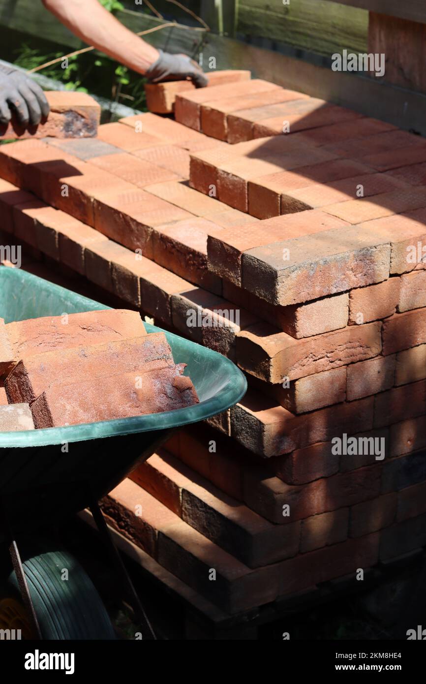 Man's hand holding red brick. Construction and building works concept. House renovation in process. Stock Photo