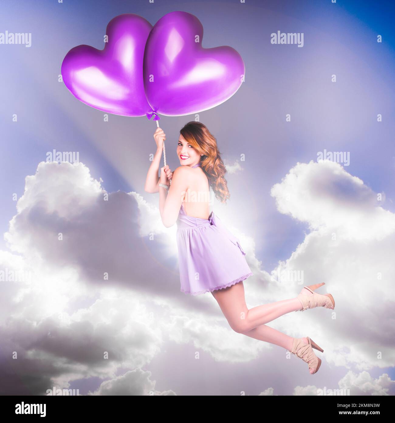 A scene of velvet romances with love struck pinup girl taken to air bound bliss with ballooning hearts Stock Photo