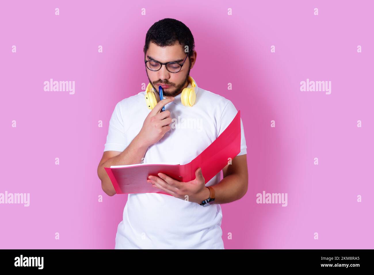 A closeup of a young student in casual clothes holding a folder with ...