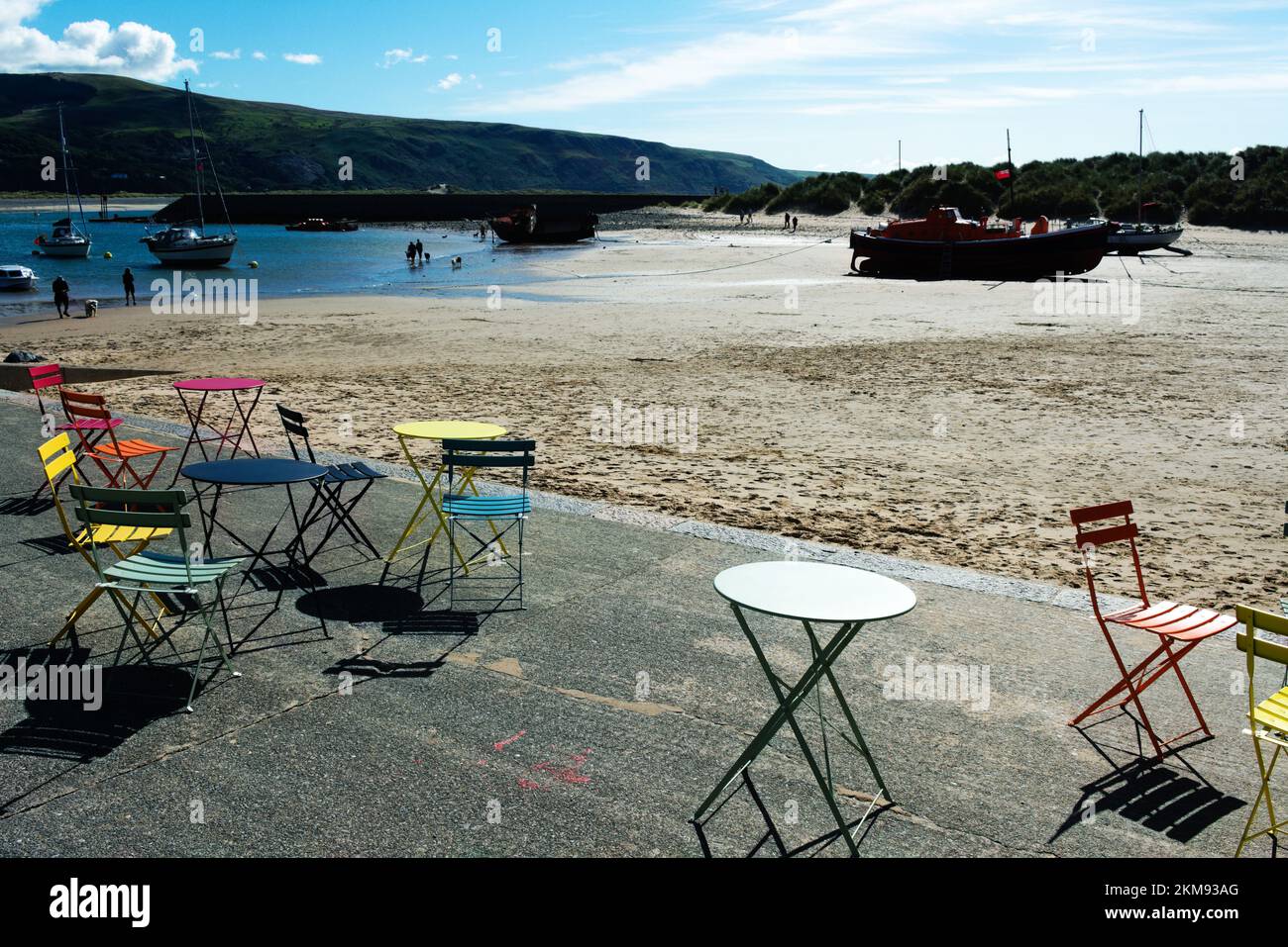 Barmouth - Wales - September 16 2022 : Beautiful .summer beach scene with colourful tables and chairs at a seafront cafe. Typical British seaside land Stock Photo