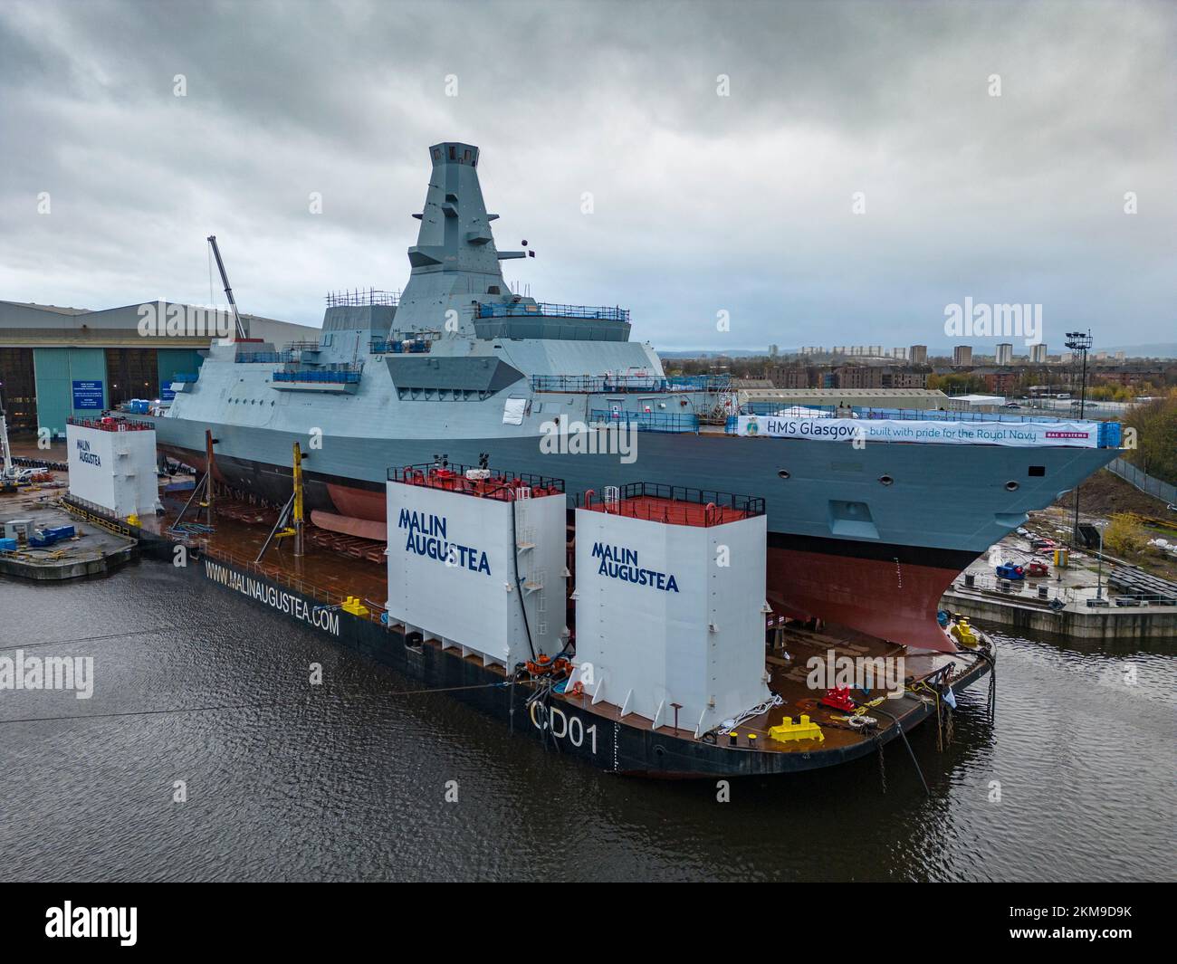Glasgow, Scotland, UK. 26th November 2022. View of HMS Glasgow, a Type 26 anti-submarine frigate, on launching barge at BAE Systems Govan shipyard. Next week she will be transported to nearby Loch Long and launched from the barge. The waters around the River Clyde are too shallow for the barge to submerge during the launch, Iain Masterton/Alamy Live News. Stock Photo