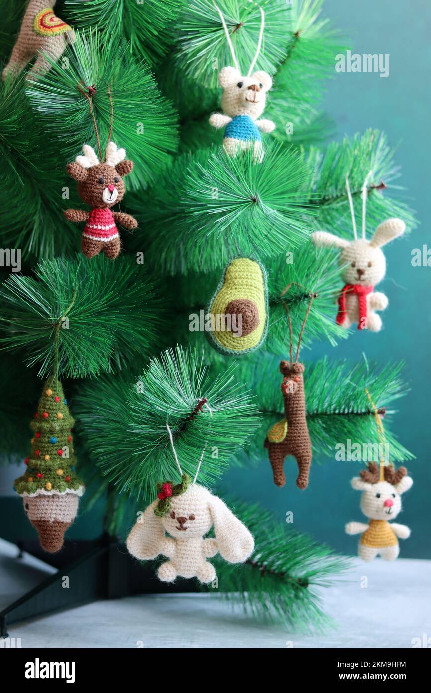 Hand made Christmas toys on a tree. Cute crochet decorations close up photo. Eco-friendly Christmas toys. Stock Photo