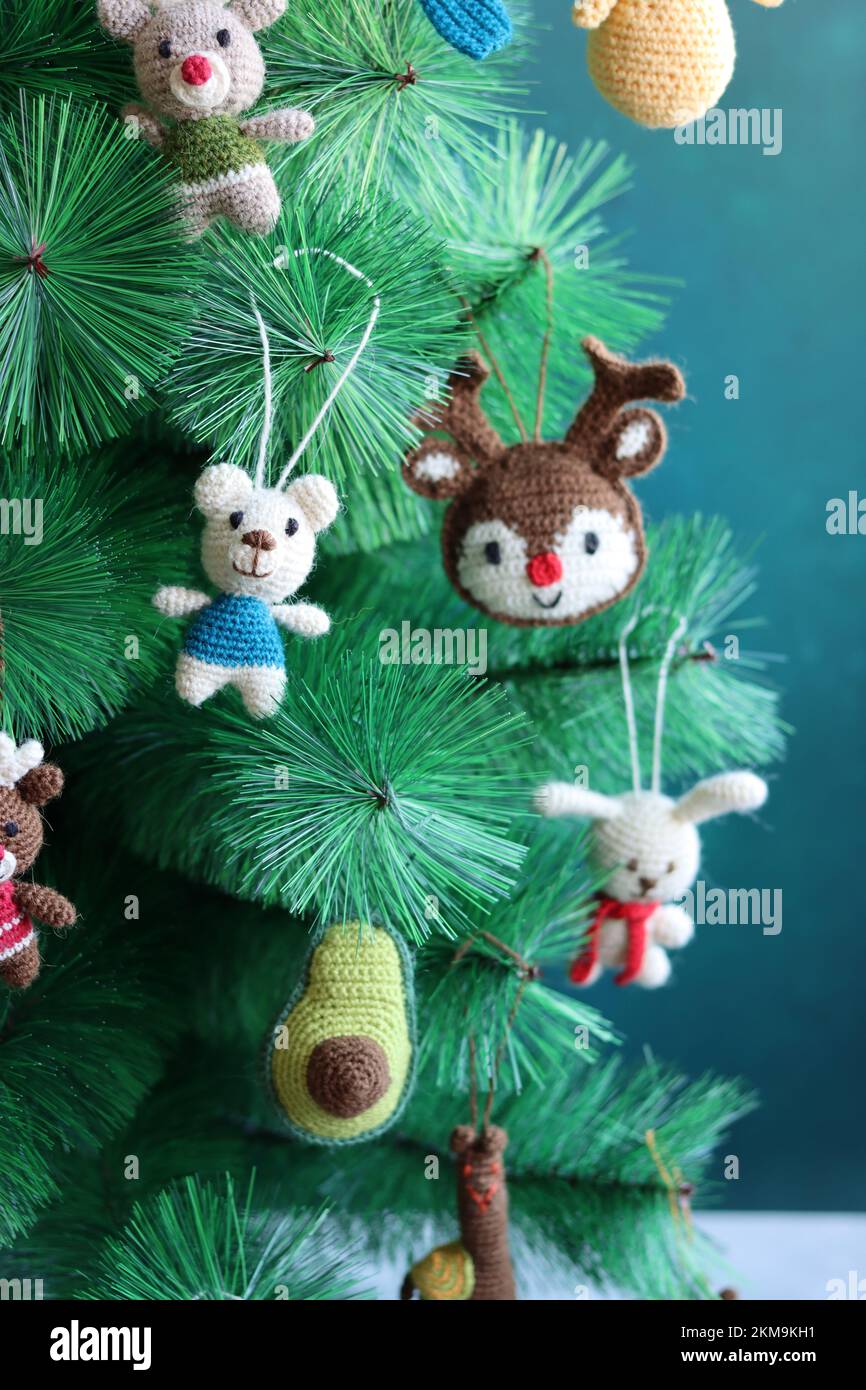 Hand made Christmas toys on a tree. Cute crochet decorations close up photo. Eco-friendly Christmas toys. Stock Photo