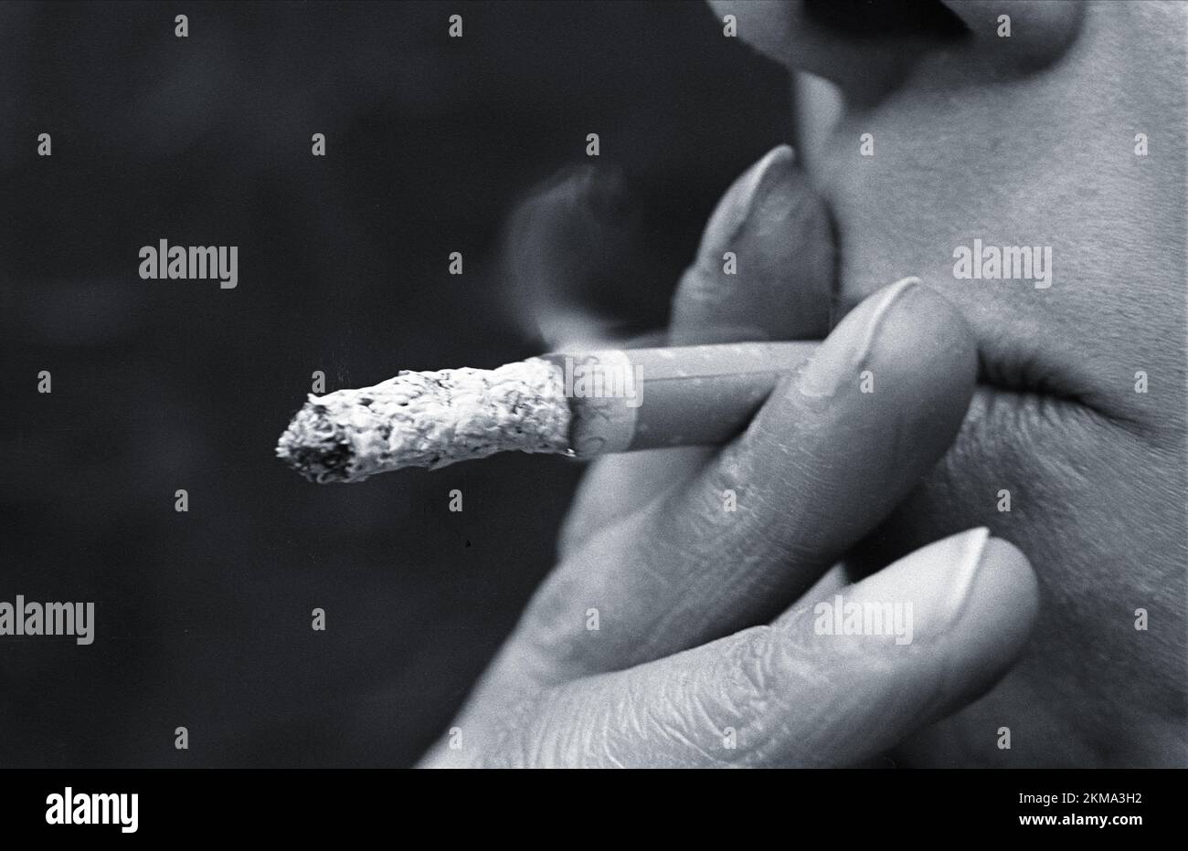 Close up of mouth of smoker deeply inhaling cigarette smoke hi-res ...