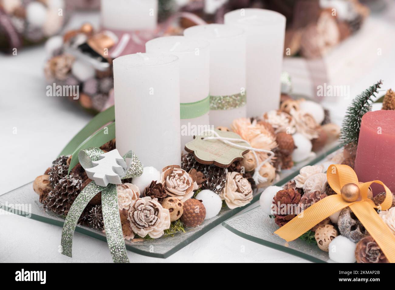 Advent candle holder or Advent wreath with four white candles in a row, green ribbons, pine