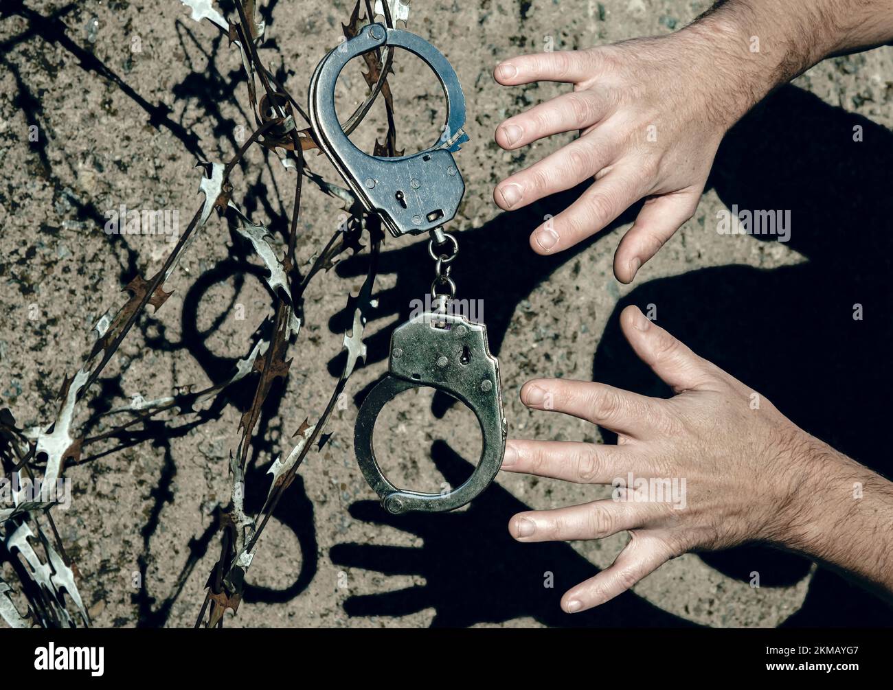 The shadow of a criminal in handcuffs on the prison wall. Law. Prison