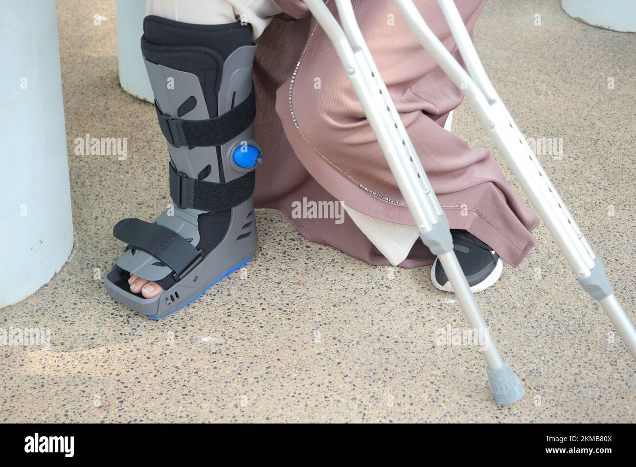 women broken feet with a grey plastic boot ankle brace injury protecting boot Stock Photo Alamy