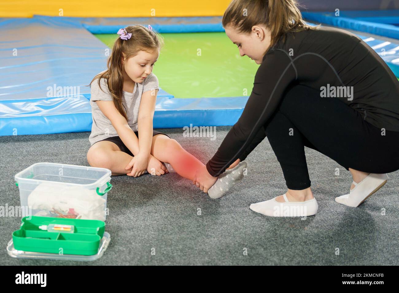 Little girl having pain in ankle and getting help after jumping on