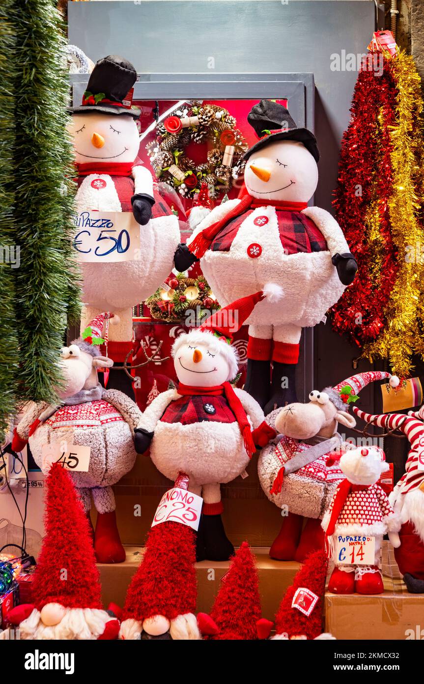 Christmas decorations, Santa Claus puppets, and Snowman puppets for sale in a shop. Stock Photo