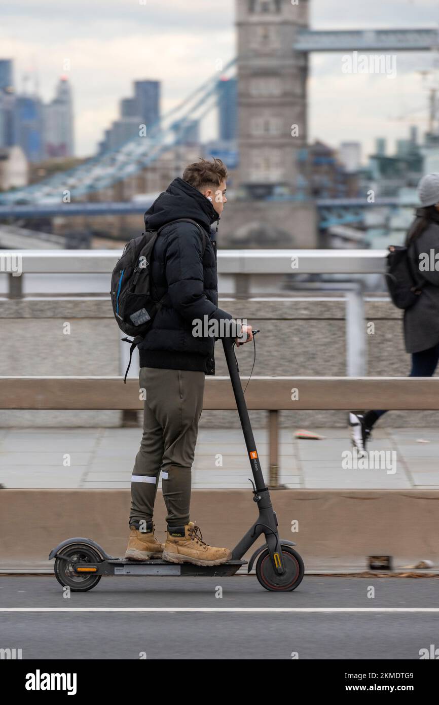 A man riding an escooter along London Bridge. Riding a privately owned